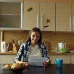Attractive happy woman recieve good news reading letter in the kitchen while have breakfast at home