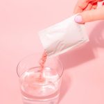 A person pouring a drink into a glass